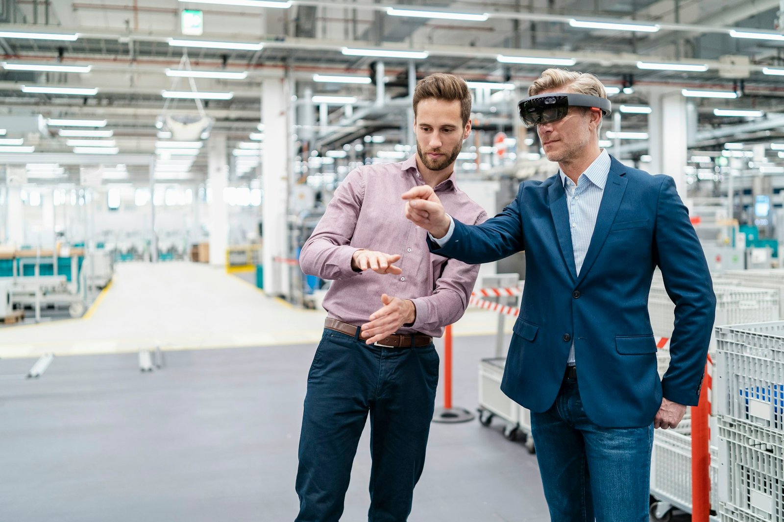 Two businessmen with AR glasses in a modern factory