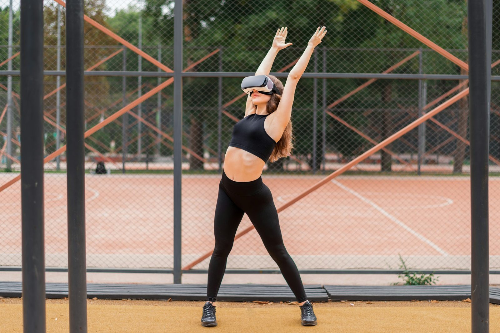 Woman in VR headset doing exercises on a sports field